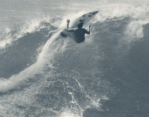 Ryan Ragan carving off the top of a wave with spray trailing