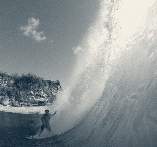 Ryan Ragan barreled on a green wave, shot from the water with cliffs behind
