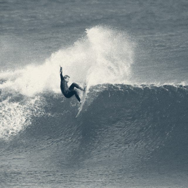 Ryan Ragan throwing a huge fan of spray off the top of a wave
