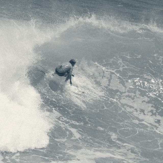 Ryan Ragan in a contest jersey snapping on a turquoise wave