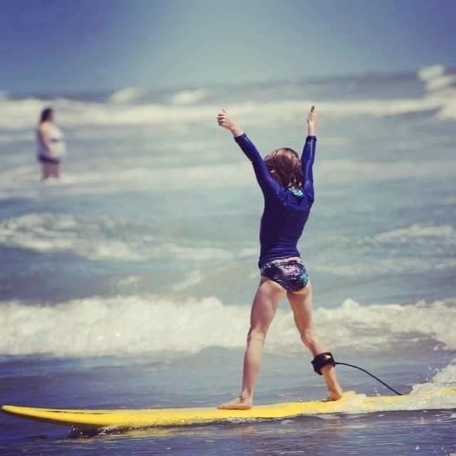 Student celebrating a ride with arms raised, seen from behind