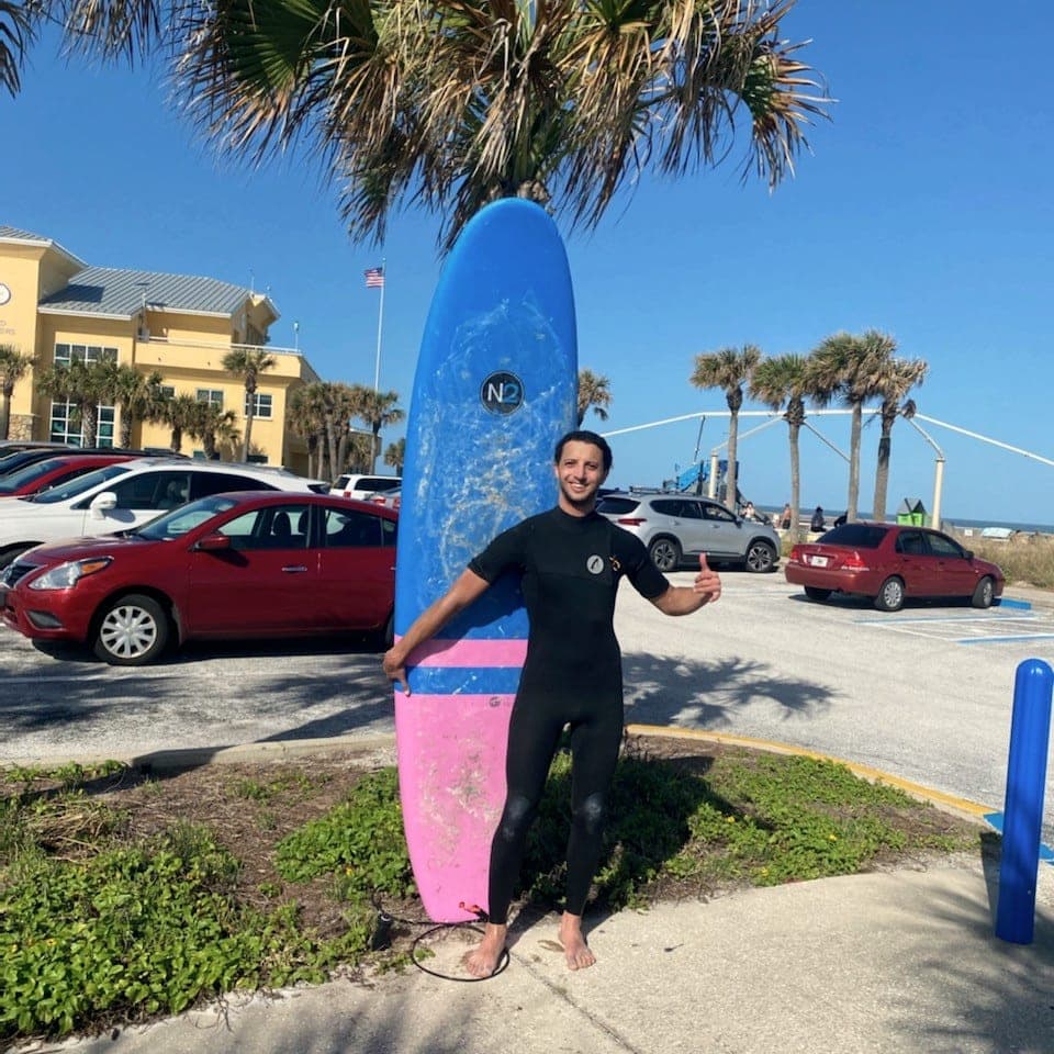 Surfer with a longboard at the beach approach parking lot