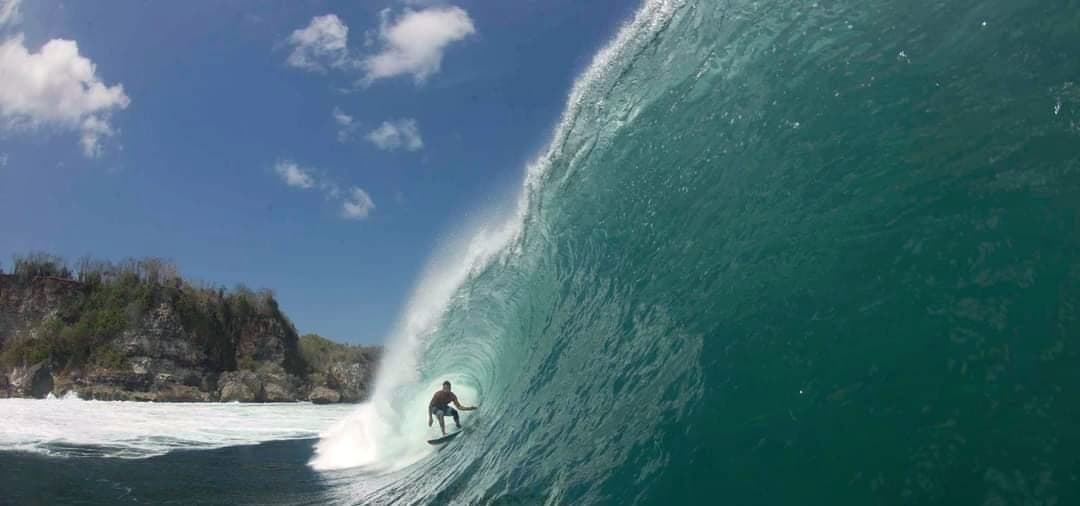 Ryan Ragan set deep in a hollow green barrel with a headland behind