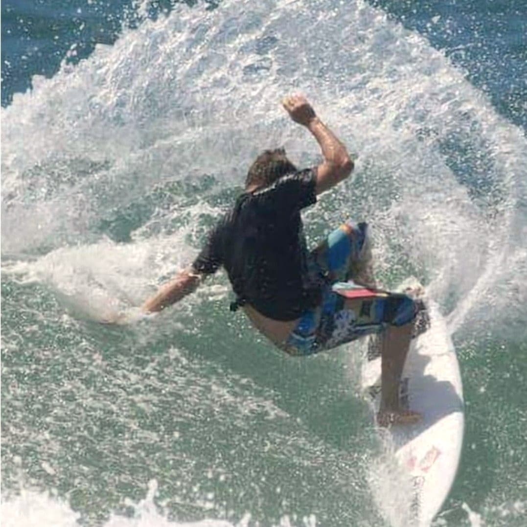 Ryan Ragan hitting the top of a wave and throwing a wall of spray
