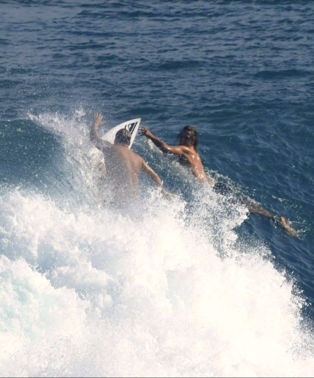 Ryan Ragan riding through the foam with another surfer alongside