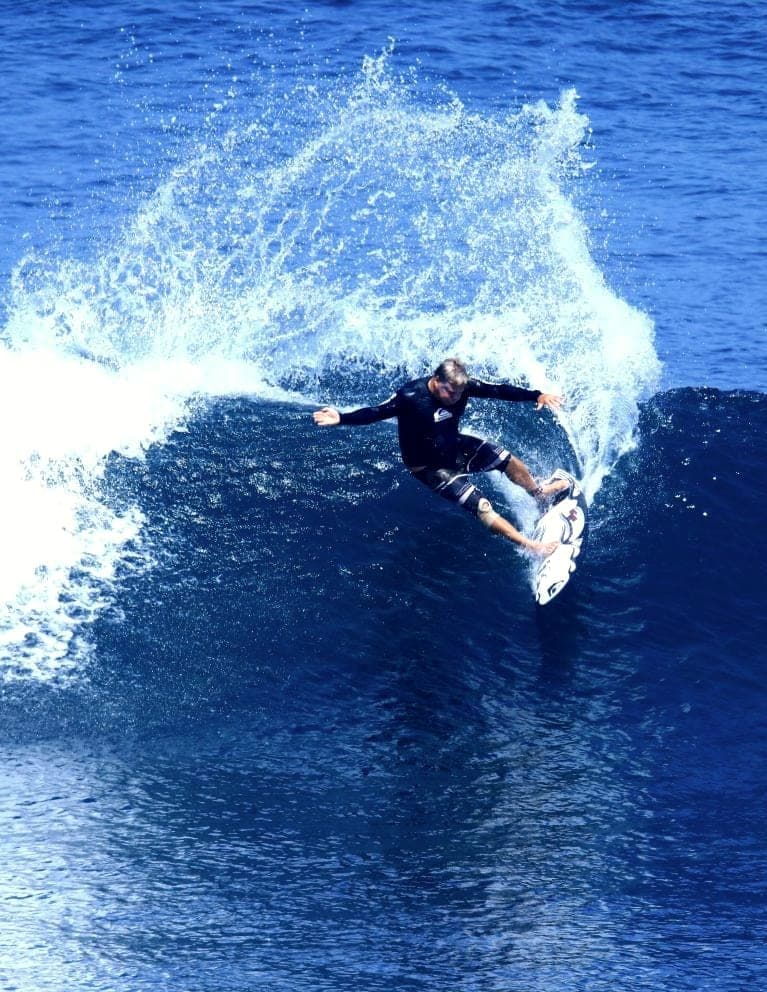Ryan Ragan throwing a snap with spray over deep blue water