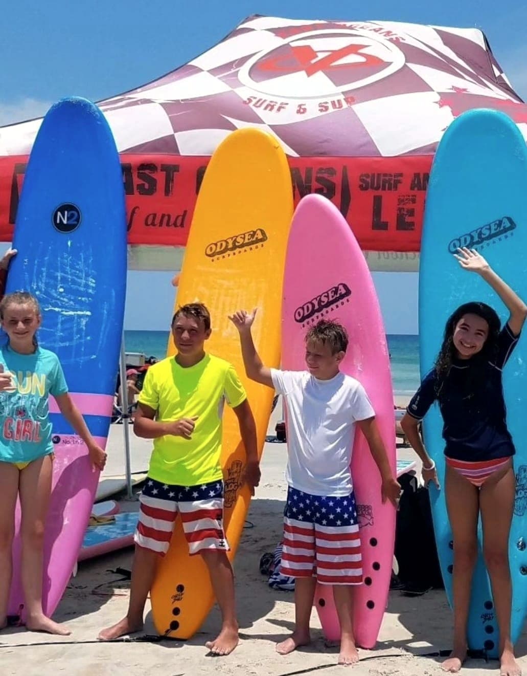 Students standing with their boards beside the lesson tent