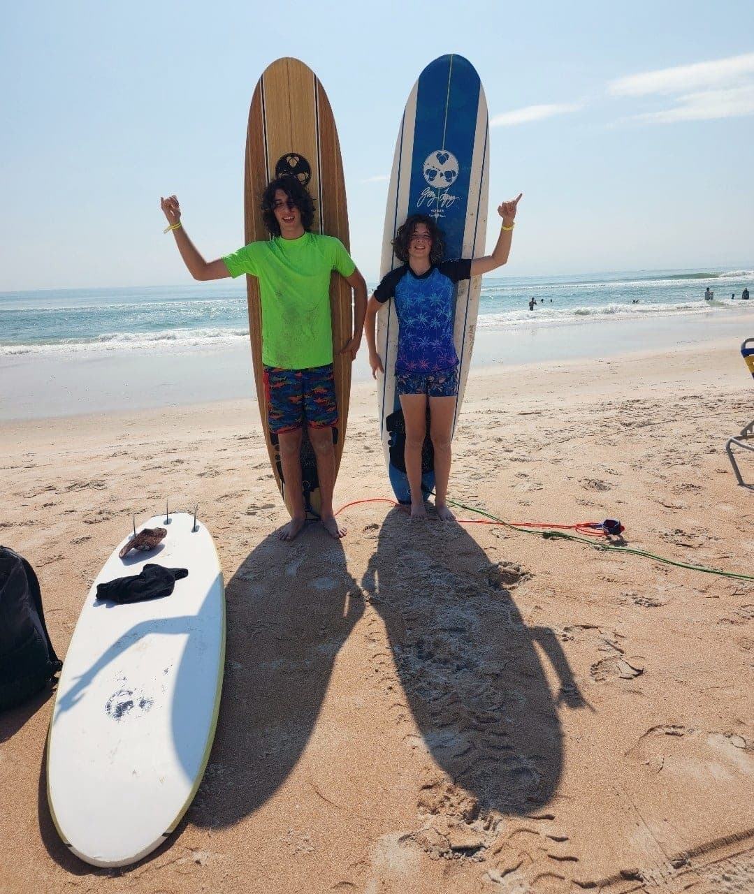 Two students standing between two upright boards on the sand